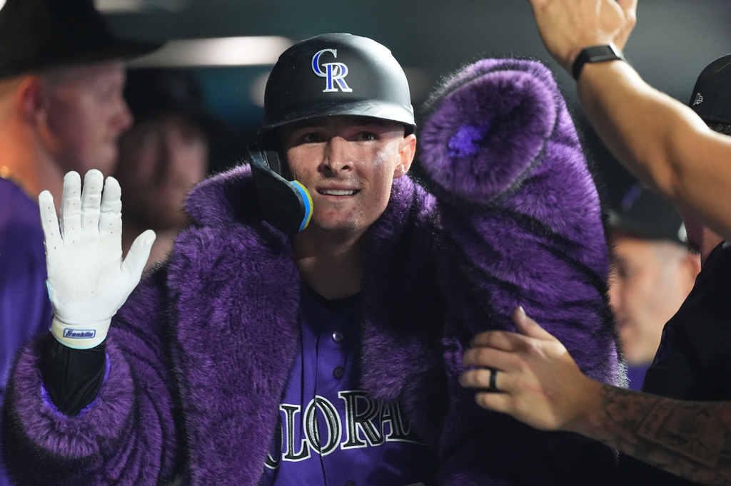 Colorado Rockies' Mickey Moniak is congratulated as he returns to the dugout after hitting a solo home run off Tampa Bay Rays relief pitcher Michael Grove in the eighth inning of a baseball game Monday, Aug. 3, 2026, in Denver. (AP Photo/David Zalubowski)