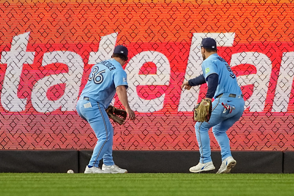 Toronto Blue Jays outfielders Davis Schneider (36) and Daulton Varsho (5) try to reach the ball during the second inning of a baseball game against the New York Yankees, Thursday, May 21, 2026. in New York. (AP Photo/Eduardo Munoz Alvarez)