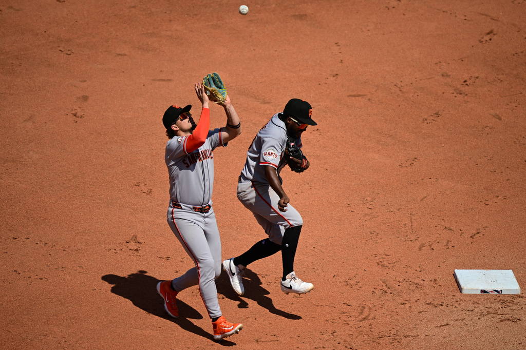 San Francisco Giants shortstop Willy Adames, left, avoids colliding with second baseman Osleivis Basabe as he catches a ball hit by Cleveland Guardians' Petey Halpin during the fourth inning of a baseball game, Thursday, Aug. 20, 2026, in Cleveland. (AP Photo/David Dermer)