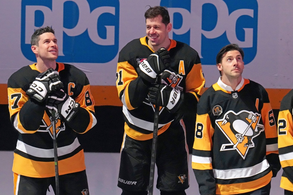 Members of the 2016 Stanley Cup Champion Pittsburgh Penguins, Sidney Crosby, left, Evgeni Malkin, center, and Kris Letang take part in a celebration of the 10th anniversary before an NHL hockey game against the New York Rangers in Pittsburgh, Saturday, Jan. 31, 2026. (AP Photo/Gene J. Puskar)