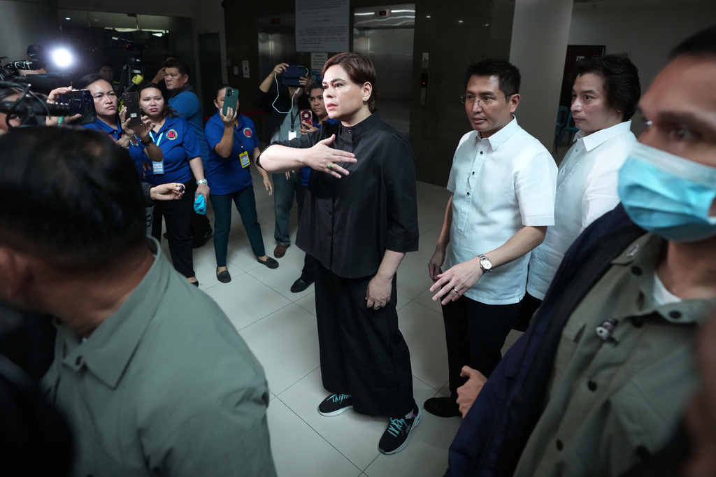 Philippine Vice President Sara Duterte walks with her lawyers after posting bail at the Quezon city justice hall, Philippines, Saturday, Sept. 5, 2026, after a warrant of arrest on charges that she publicly threatened to arrange the assassination of President Ferdinand Marcos Jr. and two other people. (AP Photo/Aaron Favila)