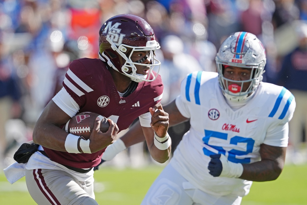 Mississippi State quarterback Kamario Taylor (1) is pursued by Mississippi defensive tackle Will Echoles (52) during the first half of an NCAA college football game Frifday, Nov. 28, 2025, in Starkville, Miss. (AP Photo/Rogelio V. Solis)