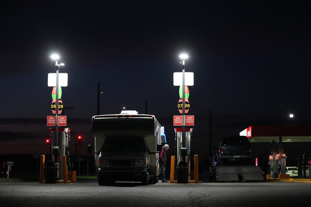 A man fiills up a recreational vehicle at a gas station on Tuesday, April 7, 2026, in Aurora, Ore. (AP Photo/Jenny Kane)