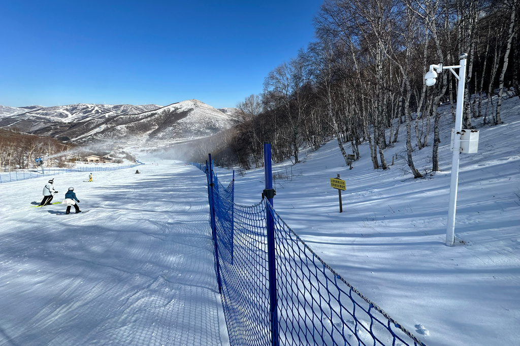 A surveillance camera installed in a forest by a ski slope watches skiers and snowboarders in Chongli, China, Sunday, Feb. 9, 2025. (AP Photo/Dake Kang)