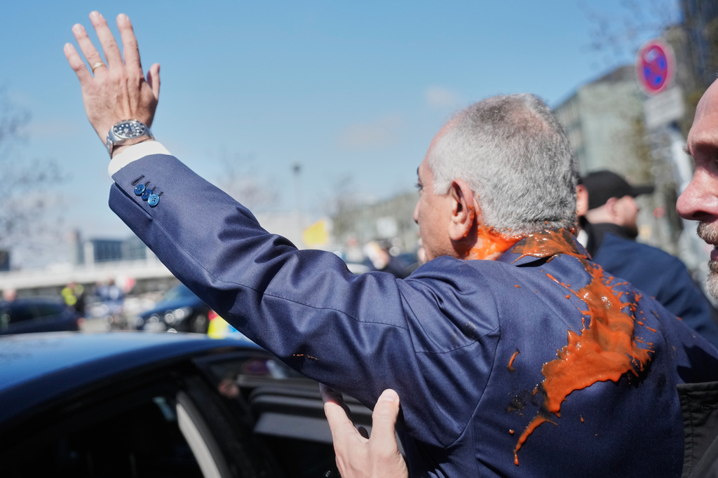Iran's Reza Pahlavi, exiled son of Shah Reza Pahlavi, waves to supporters after he was attacked with a red fluid following a news conference in Berlin, Germany, Thursday, April 23, 2026. (AP Photo/Markus Schreiber)