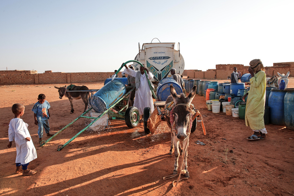 FILE - People fill water containers at a free distribution point due to water outages in Khartoum, Sudan, on Jan. 30, 2026. (AP Photo/Marwan Ali, File)