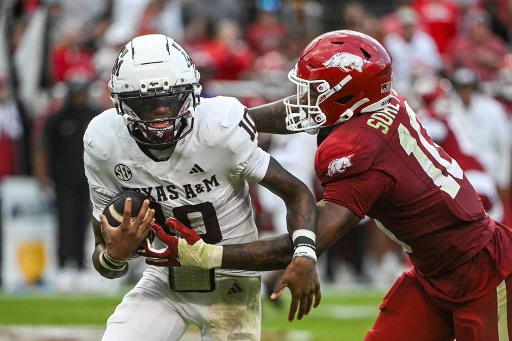 Texas A&M quarterback Marcel Reed, left, is sacked by Arkansas linebacker Xavian Sorey Jr., right, during the first half of an NCAA college football game Saturday, Oct. 18, 2025, in Fayetteville, Ark. (AP Photo/Michael Woods)