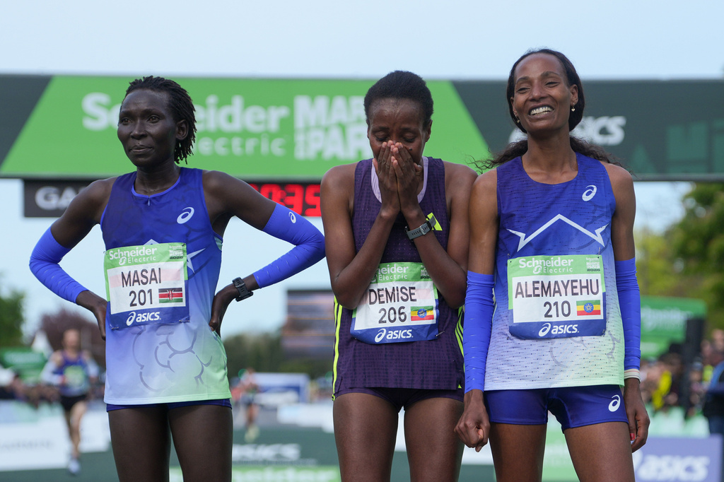From left, Kenya's Magdalyne Masai, Ethiopia's Shure Demise and Ethiopia's Misgane Alemayehu pose after crossing the finish line of the women's race of the Paris marathon, in Paris, Sunday, April 12, 2026. (AP Photo/Thibault Camus)