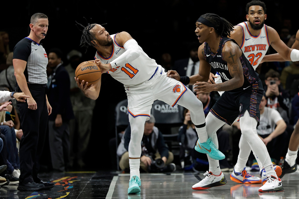 New York Knicks guard Jalen Brunson (11) looks to pass the ball around Brooklyn Nets guard Terance Mann during the second half of an NBA basketball game, Monday, Nov. 24, 2025, in New York. (AP Photo/Adam Hunger)
