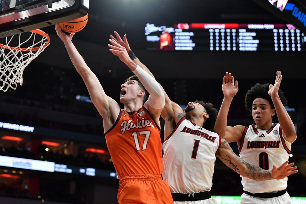 Virginia Tech guard Neoklis Avdalas (17) attempts a layup past Louisville guard J'vonne Hadley (1) and guard Mikel Brown Jr. (0) during the first half of an NCAA college basketball game in Louisville, Ky., Saturday, Jan. 24, 2026. (AP Photo/Timothy D. Easley)