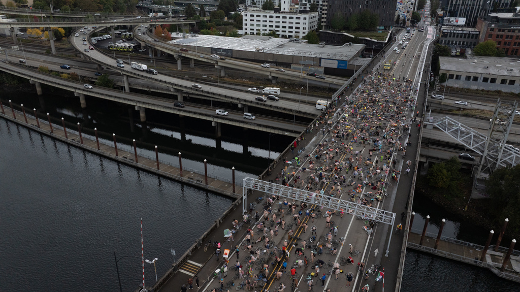 EDS NOTE: NUDITY - Cyclists in the Naked Bike Ride in protest against Donald Trump's attempts to mobilize the National Guard ride across the Burnside Bridge, Sunday, Oct. 12, 2025, in Portland, Ore. (AP Photo/Jenny Kane)