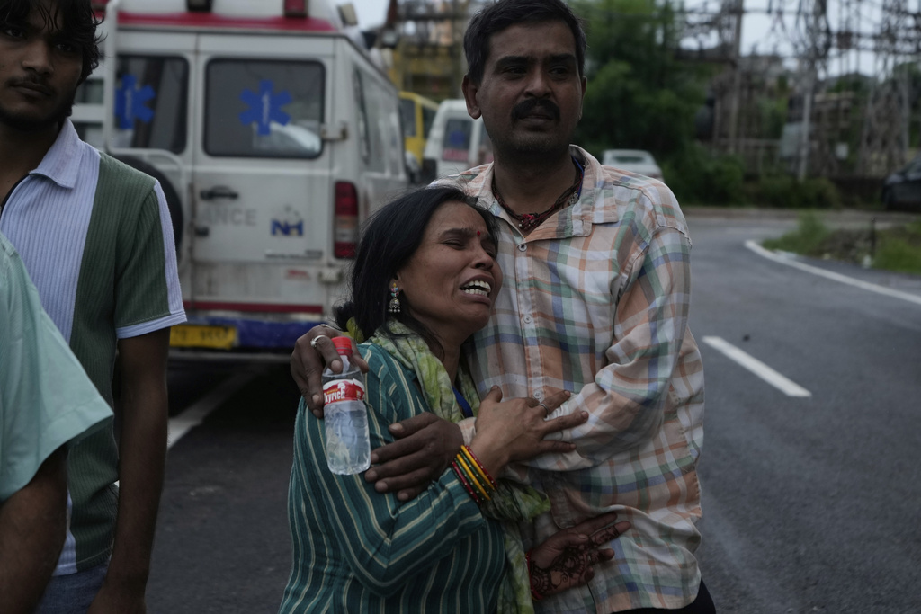 A pilgrim couple mourns the death of family members following a landslide due to floods on the route to the Shri Mata Vaishno Devi Temple, at the Government Medical Hospital in Jammu, India, Wednesday, Aug. 27, 2025. (AP Photo/Channi Anand)