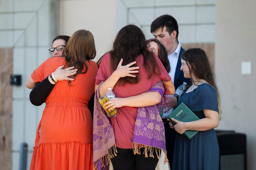 People are reunited at Trillium NCG Theatre with friends and family who were present during a nearby shooting and structure fire at The Church of Jesus Christ of Latter-day Saints on McCandlish Road in Grand Blanc, Mich., Sunday, Sept. 28, 2025. (Katy Kildee/Detroit News via AP) People are reunited at Trillium NCG Theatre with friends and family who were present during a nearby shooting and structure fire at The Church of Jesus Christ of Latter-day Saints on McCandlish Road in Grand Blanc, Mich., Sunday, Sept. 28, 2025. (Katy Kildee/Detroit News via AP)