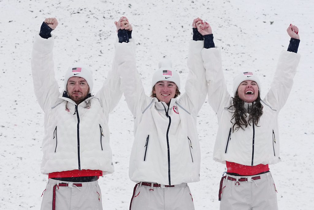From left, gold medalists United States' Christopher Lillis, Connor Curran and Kaila Kuhn celebrates after the freestyle skiing mixed team aerials final at the 2026 Winter Olympics, in Livigno, Italy, Saturday, Feb. 21, 2026. (AP Photo/Gregory Bull)