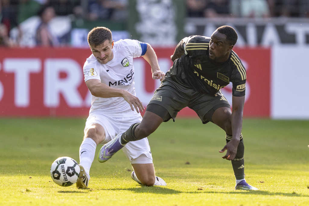 Gütersloh's Björn Rother, left, and Berlin's Ilyas Ansah in action during the DFB Cup first round between FC Gütersloh and 1. FC Union Berlin in Gütersloh, Germany, Friday Aug. 15, 2025. (David Inderlied/dpa via AP)