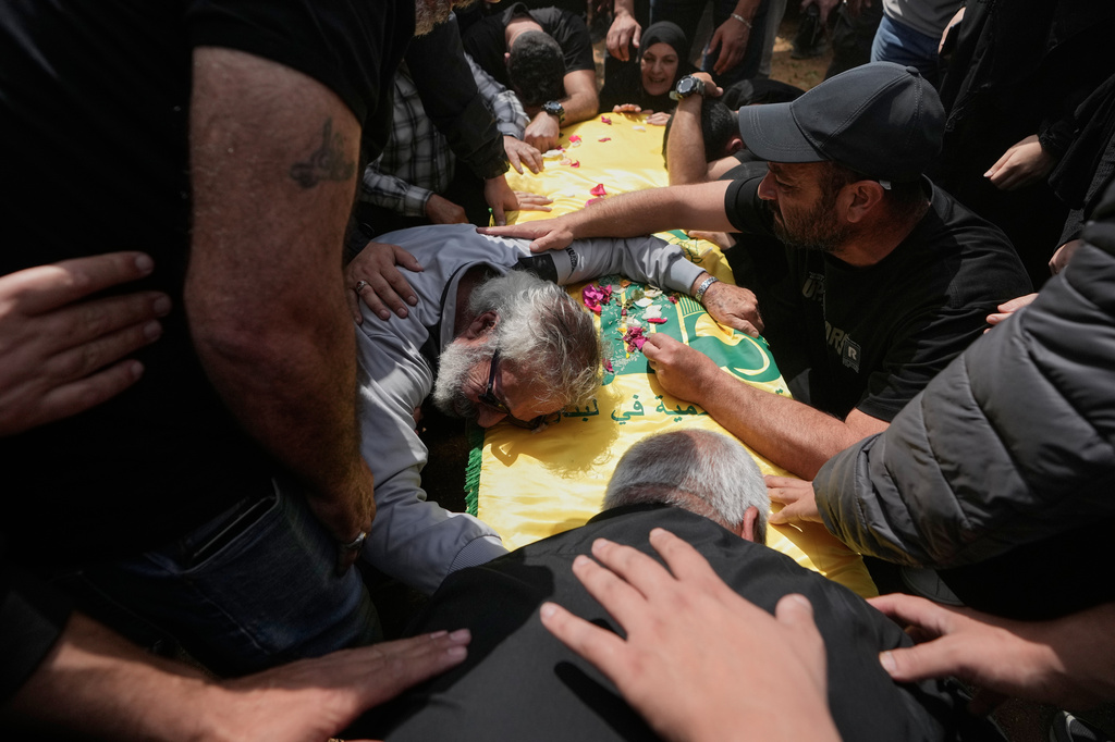 A man mourns over the coffin of a Hezbollah fighter who was killed in the war between Hezbollah and Israel during a mass funeral in Bazouriyeh village, south Lebanon, Monday, April 20, 2026. (AP Photo/Mohammed Zaatari)