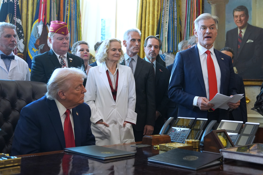 President Donald Trump listens as Centers for Medicare & Medicaid Services administrator Dr. Mehmet Oz speaks during an executive order signing in the Oval Office of the White House, Thursday, Dec. 18, 2025, in Washington. (AP Photo/Evan Vucci)