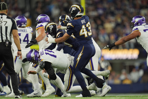 Minnesota Vikings quarterback Carson Wentz (11) is hit by Los Angeles Chargers cornerback Cam Hart (20) and linebacker Troy Dye (43) during the second half of an NFL football game Thursday, Oct. 23, 2025, in Inglewood, Calif. (AP Photo/Gregory Bull) Minnesota Vikings quarterback Carson Wentz (11) is hit by Los Angeles Chargers cornerback Cam Hart (20) and linebacker Troy Dye (43) during the second half of an NFL football game Thursday, Oct. 23, 2025, in Inglewood, Calif. (AP Photo/Gregory Bull)