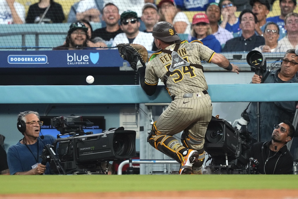 San Diego Padres catcher Freddy Fermin is unable the catch a foul ball hit by Los Angeles Dodgers' Andy Pages during the second inning of a baseball game Friday, Aug. 15, 2025, in Los Angeles. (AP Photo/Mark J. Terrill)