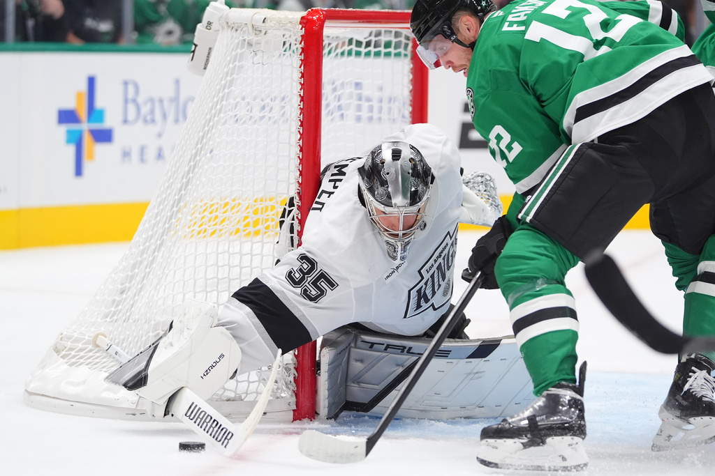 Los Angeles Kings goaltender Darcy Kuemper (35) defends the goal against Dallas Stars center Radek Faksa (12) during the first period of an NHL hockey game Thursday, Oct. 23, 2025, in Dallas. (AP Photo/LM Otero)