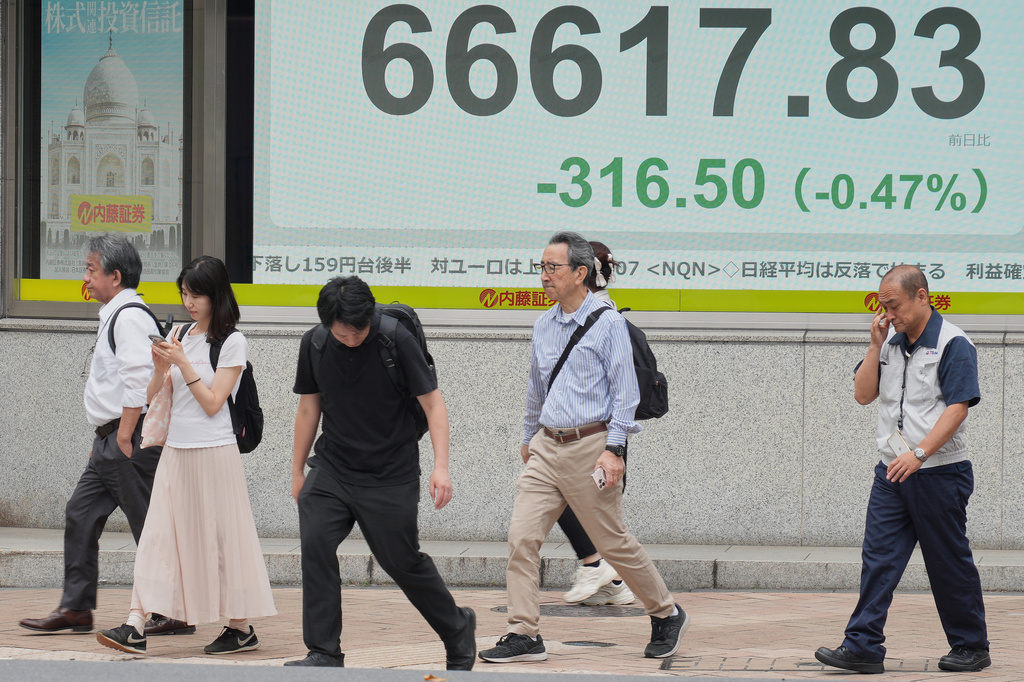 People walk in front of an electronic stock board showing Japan's Nikkei index at a securities firm Tuesday, June 2, 2026, in Tokyo. (AP Photo/Eugene Hoshiko)