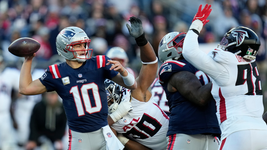 New England Patriots quarterback Drake Maye (10) works under pressure by the Atlanta Falcons during the second half of an NFL football game, Sunday, Nov. 2, 2025, in Foxborough, Mass. (AP Photo/Charles Krupa)