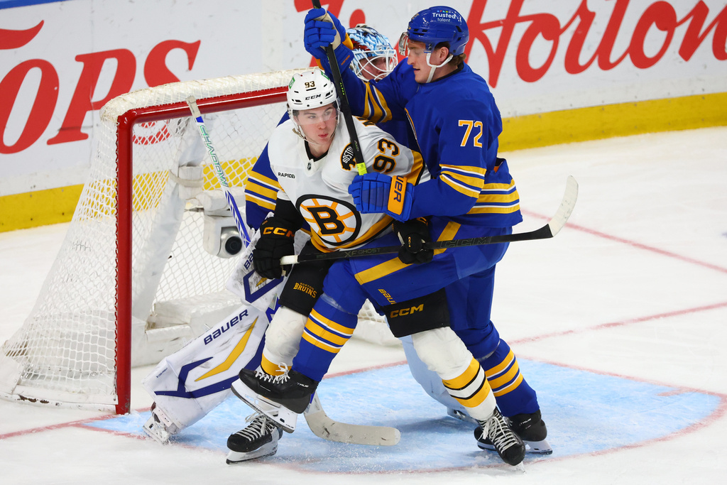 Boston Bruins center Fraser Minten (93) and Buffalo Sabres center Tage Thompson (72) battle for position during the third period of an NHL hockey game Wednesday, March 25, 2026, in Buffalo, N.Y. (AP Photo/Jeffrey T. Barnes)