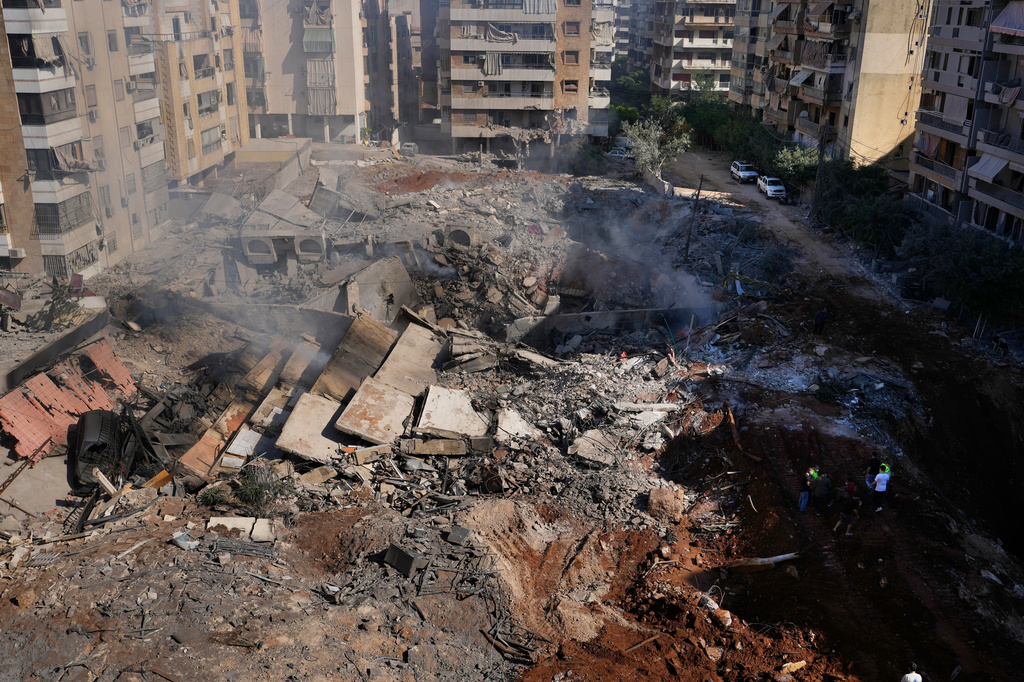 FILE - People gather at the site of the assassination of Hezbollah leader Hassan Nasrallah in Beirut's southern suburbs, Sept. 29, 2024. (AP Photo/Hassan Ammar, File)