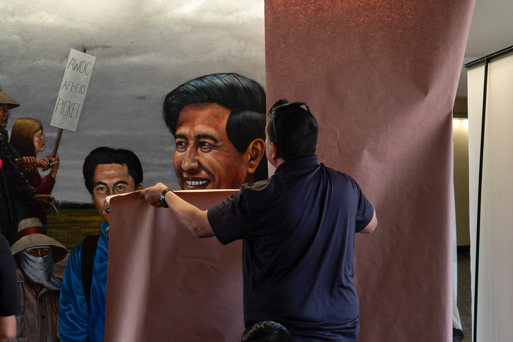 A worker covers a mural by Emigdio Vasquez depicting Cesar Chavez, at Santa Ana College in Santa Ana, Calif., Thursday, March 19, 2026. (AP Photo/Jae C. Hong)