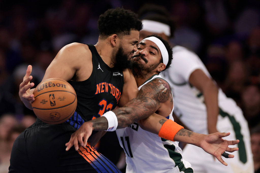 Milwaukee Bucks guard Gary Harris, right, defends a driving New York Knicks center Karl-Anthony Towns during the first half of an NBA basketball game, Friday, Nov. 28, 2025, in New York. (AP Photo/Adam Hunger)
