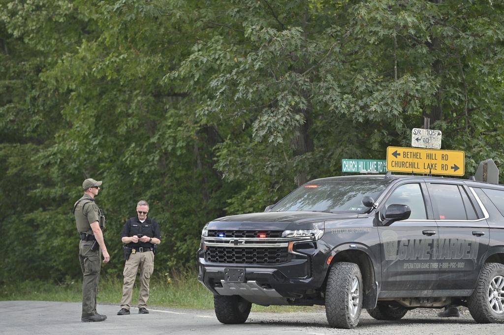 Police officers block the street leading to where two Pennsylvania state troopers were ambushed and shot Thursday, Aug. 7, 2025, near the village of Thompson in Susquehanna County, Pa. (AP Photo/Aimee Dilger)