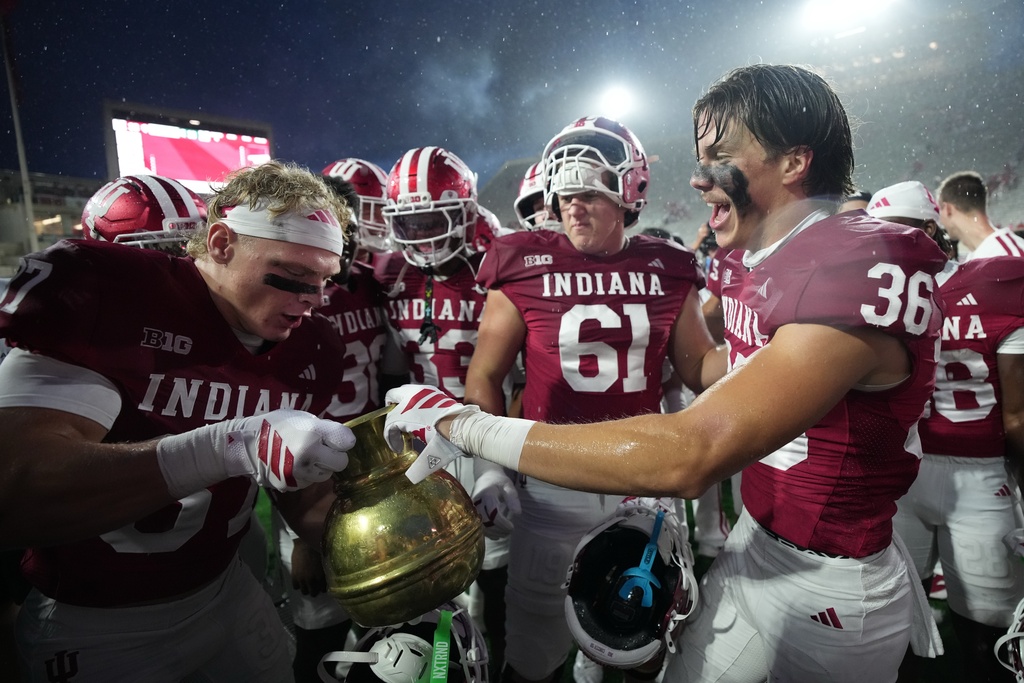 Indiana players celebrate with the Old Brass Spittoon following an NCAA college football game against the Michigan State, Saturday, Oct. 18, 2025, in Bloomington, Ind. (AP Photo/AJ Mast)