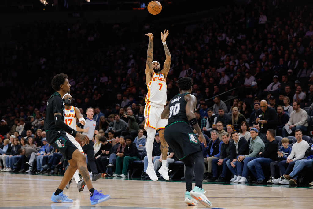 Atlanta Hawks guard Nickeil Alexander-Walker (7) goes up for a 3-point shot while Minnesota Timberwolves forward Julius Randle (30) and forward Jaden McDaniels, left, defend during the first half of an NBA basketball game, Monday, Feb. 9, 2026, in Minneapolis. (AP Photo/Bailey Hillesheim)
