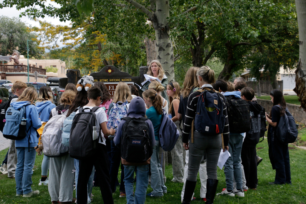 A seventh-grade history class from Santa Fe Preparatory School visits a historical marker downtown during a field trip Wednesday, Oct. 8, 2025, in Santa Fe, N.M. (AP Photo/Stacy Thacker)
