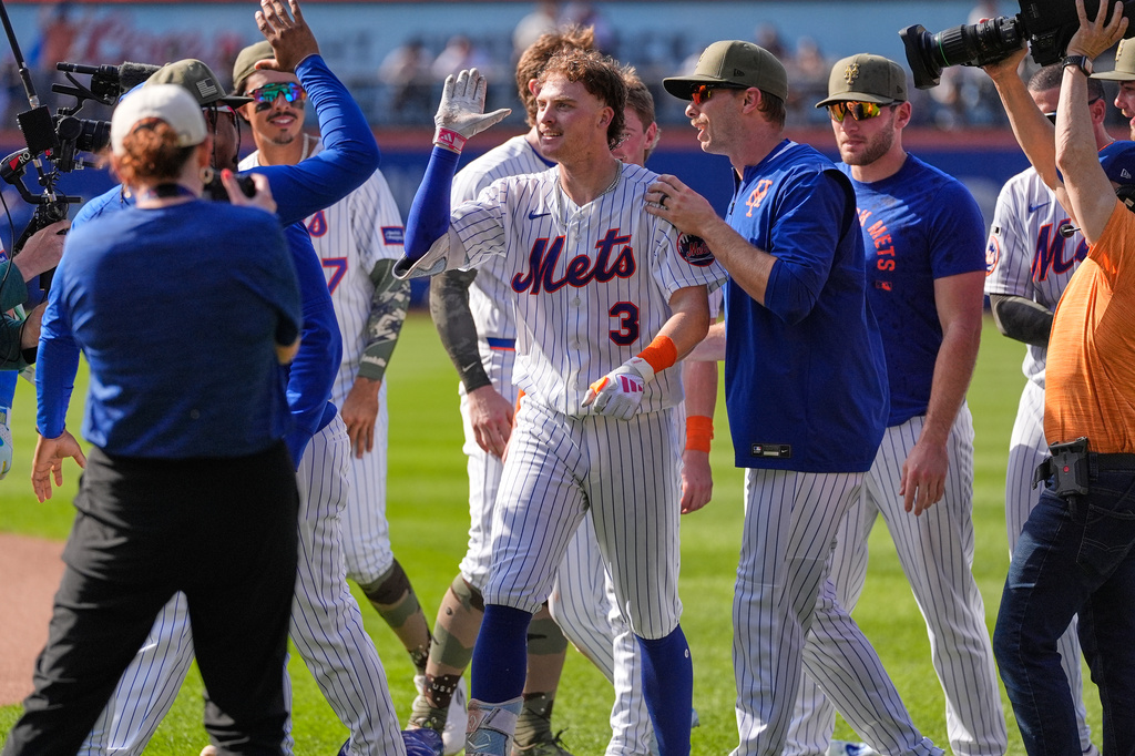 New York Mets' Carson Benge, center, celebrates with teammates after he hit into the game-winning fielders choice during the tenth inning of a baseball game against the New York Yankees, Sunday, May 17, 2026, in New York. (AP Photo/Seth Wenig)