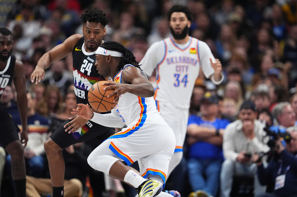 Oklahoma City Thunder guard Luguentz Dort, front, drives past Denver Nuggets guard Jalen Pickett (24) in the first half of an NBA basketball game Friday, April 10, 2026, in Denver. (AP Photo/David Zalubowski)