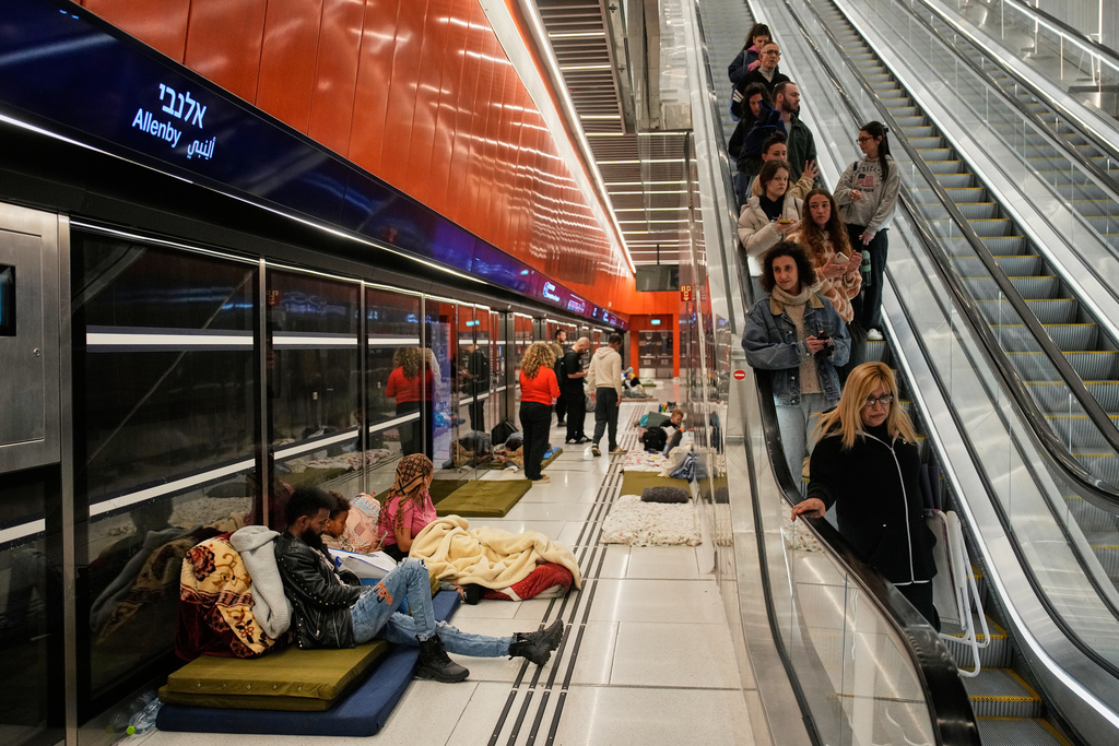 People take shelter in an underground metro station as air raid sirens warn of incoming Iranian missiles in Tel Aviv, Israel, Saturday, March 7, 2026. (AP Photo/Ohad Zwigenberg)