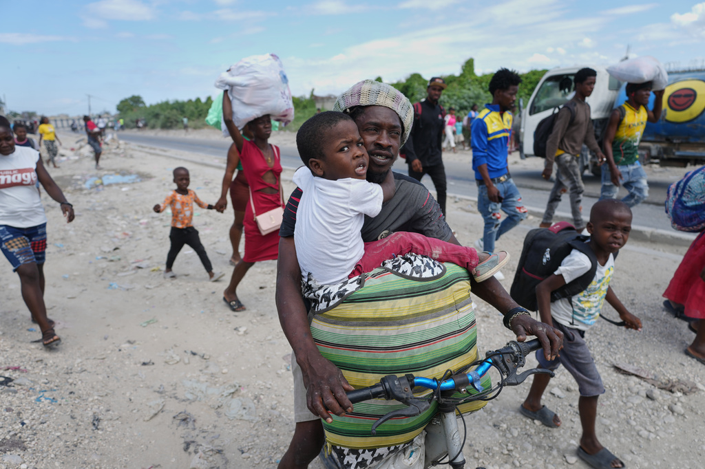 Residents flee their homes to escape clashes between armed gangs in Port-au-Prince, Haiti, Monday, May 11, 2026. (AP Photo/Odelyn Joseph)
