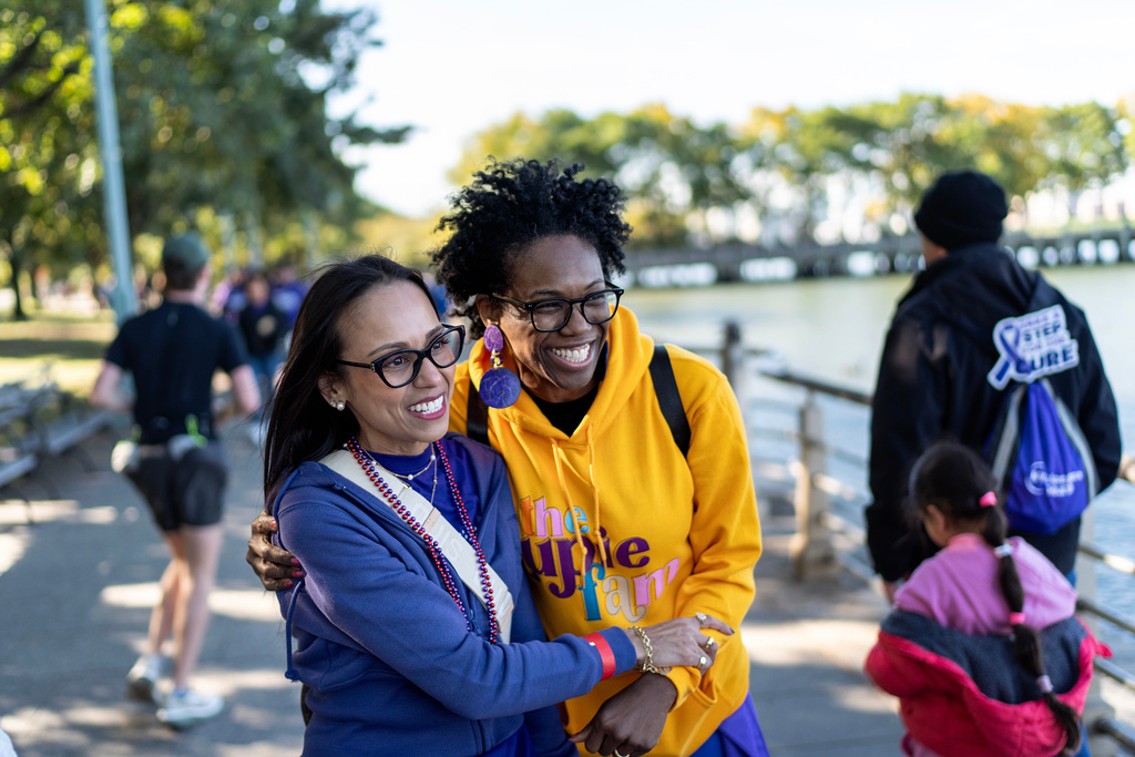 Ruth Wilson, left, embraces Adrienne Nicole, both whom have lupus, as they bump into each other at the Walk with Us to Cure Lupus fundraising event, Saturday, Oct. 18, 2025, in New York. (AP Photo/David Goldman)
