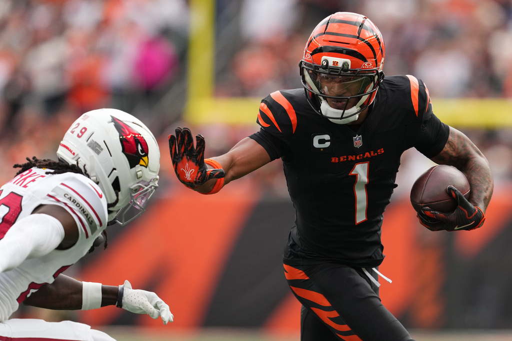 Cincinnati Bengals wide receiver Ja'Marr Chase (1) runs in a touchdown as Arizona Cardinals cornerback Denzel Burke defends during the first half of an NFL football game Sunday, Dec. 28, 2025, in Cincinnati. (AP Photo/Jeff Dean)