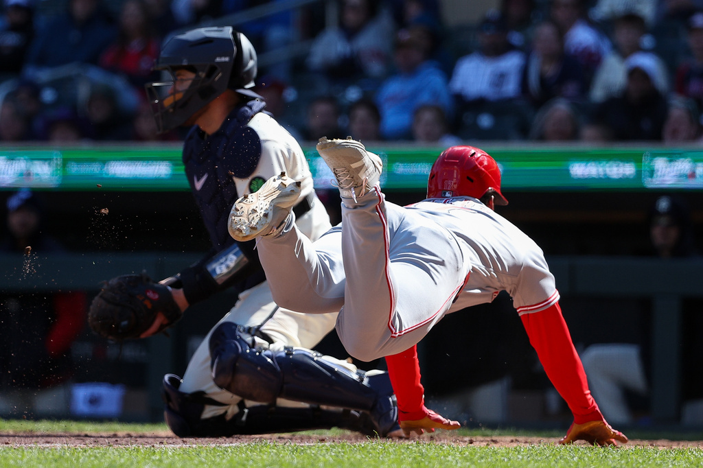 Cincinnati Reds' Dane Myers, right, scores on an RBI double hit by TJ Friedl during the ninth inning of baseball game against the Minnesota Twins, Sunday, April 19, 2026, in Minneapolis. (AP Photo/Matt Krohn)