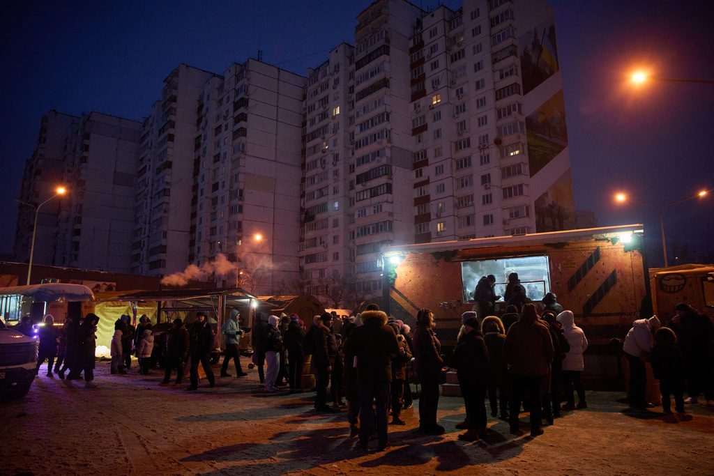 People stand in line for free hot meals that veterans of the 3rd Separate Assault Brigade of Ukraine's Armed Forces serve in residential neighborhood as repeated Russian air attacks on the country's energy sector leave people without power, heating and water in the harshest winter in decades in Kyiv, Ukraine, Sunday, Feb. 8, 2026. (AP Photo/Efrem Lukatsky)