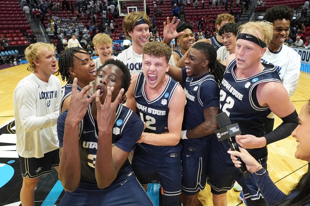 Utah State players celebrate after the first round of the NCAA college basketball tournament against Villanova, Friday, March 20, 2026, in San Diego. (AP Photo/Marcio Jose Sanchez)