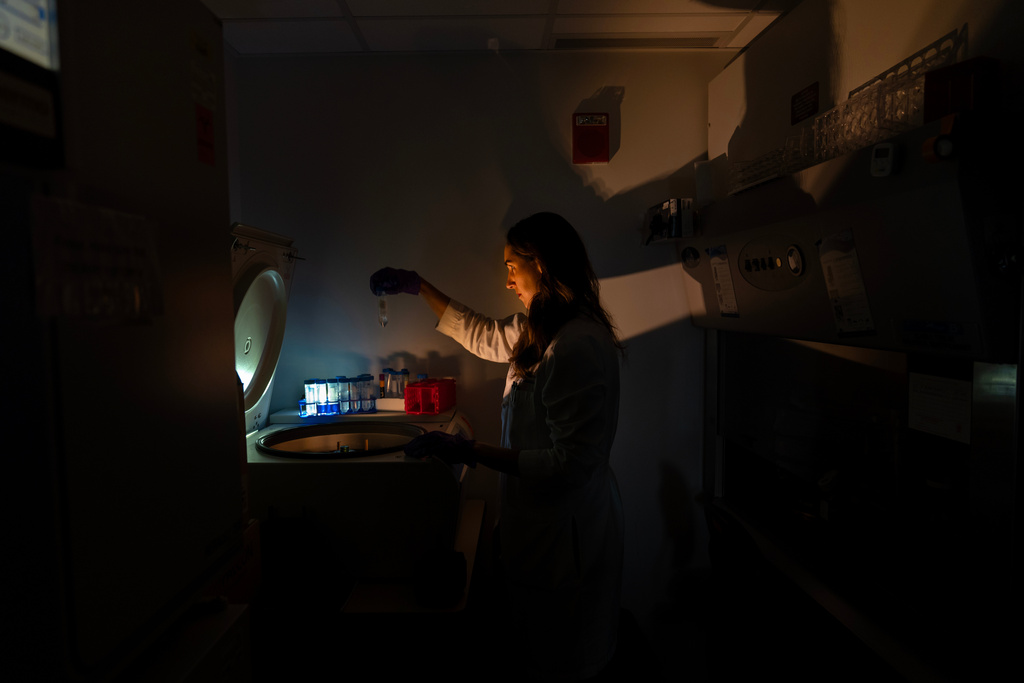 Dr. Laura Lewandowski, a pediatric rheumatologist and assistant clinical investigator, poses for a portrait at a centrifuge with tubes containing patient samples for autoimmunity testing in the lab where she works at the National Institutes of Health, Monday, Aug. 25, 2025, in Bethesda, Md. Lewandowski leads a team studying the genetics of pediatric lupus. "I've always been a person who loves puzzles and problem solving and the big picture of how people get sick. What I'm explaining to my family is that I'm a gene hunter. I could do back flips, inside that's how I feel when I can see something new. It's amazing. What I am studying, I feel it's a super exciting moment to be doing this." (AP Photo/David Goldman)