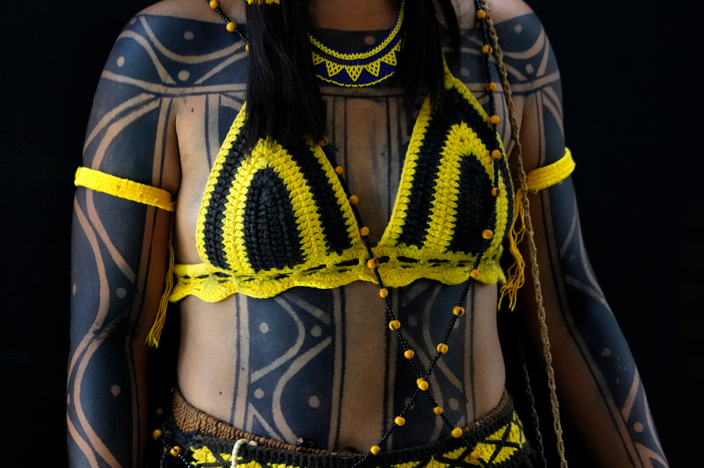 An Indigenous woman wearing traditional body paint and handcrafted clothing poses for a portrait during the opening of the "Acampamento Terra Livre," or Free Land Encampment, Brazil's largest annual Indigenous mobilization that focuses on land rights and environmental protection, in Brasilia, Brazil, Monday, April 6, 2026. (AP Photo/Eraldo Peres)
