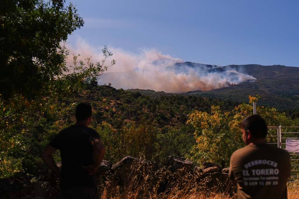 Smoke and flames rise as a wildfire advances near Burgohondo, Ávila province, Spain, Friday, July 24, 2026. (AP Photo/Manu Fernandez)