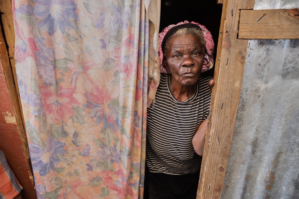 A woman looks at UNICEF staff at a shelter for families displaced by gang violence in Port-au-Prince, Haiti, Tuesday, Oct. 7, 2025.(AP Photo/Patrice Noel)