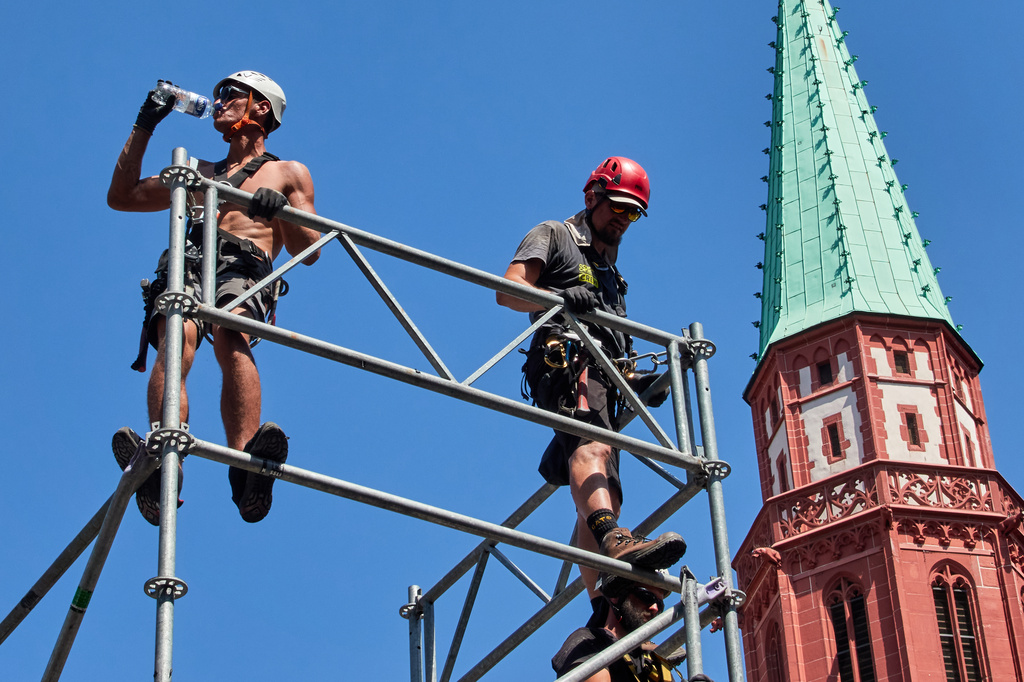 A worker drinks water as he sets up a stage for the upcoming Ironman triathlon, Frankfurt, Germany, Thursday, June 25, 2026. (AP Photo/Michael Probst)