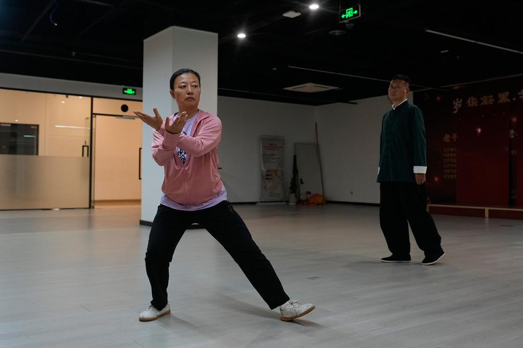 Chen Haitao, right, the 12th generation inheritor of Chen-style Tai Chi watches his student performs Tai Chi at a class in Beijing, Saturday July 11, 2026. (AP Photo/Andy Wong)