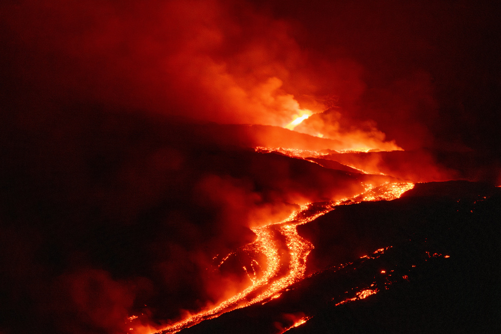 Eruptive activity continues on Mount Etna, where lava flows continue to descend on the slopes of the volcano, as seen from Serracozzo near Catania, Italy, early Tuesday, Aug. 11, 2026. (AP Photo/Simone Genovese)